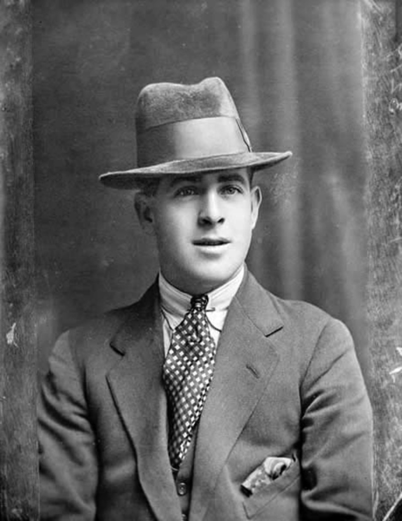 1920s Mens Fashion Suit Accessories A photo thought to capture Fred Piper, whose father was a Steam Circus Proprietor. Here, he wears popular 1920s accessories such as a geometric print tie, collar pin, fedora, and a pocket square.