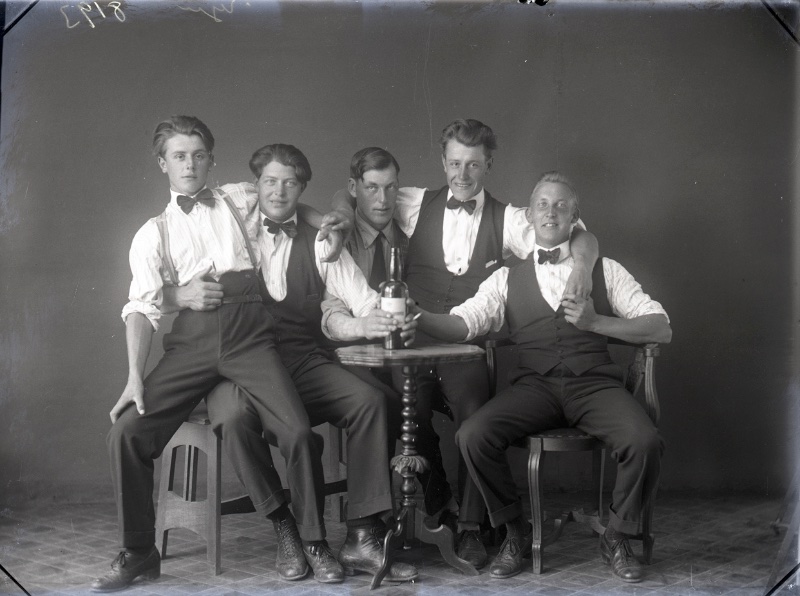 Mens Style 1920s Suspenders Braces Trousers Bow Ties Showcasing 1920s classic style, friends pose in high-waist trousers with braces, bow ties, and waistcoats.