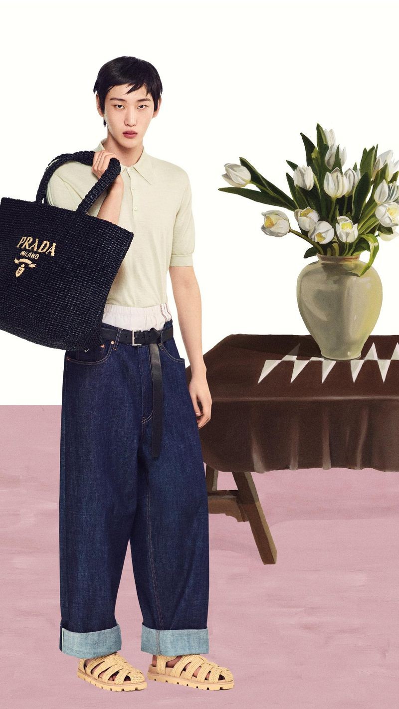 Prada Summer 2024 Campaign 006 Hamin Yu wears a cashmere polo with jeans and a black crochet tote bag for Prada's summer 2024 campaign.